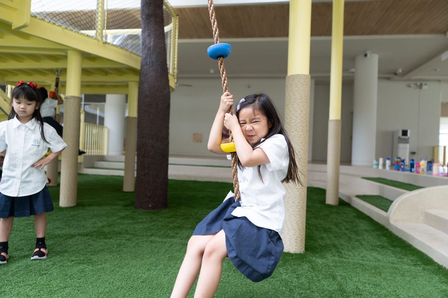 A pupil on the rope swing in the playground