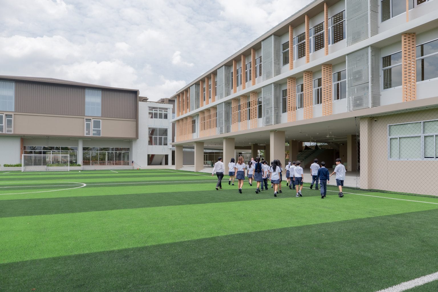 Pupils walking across the field towards the school building
