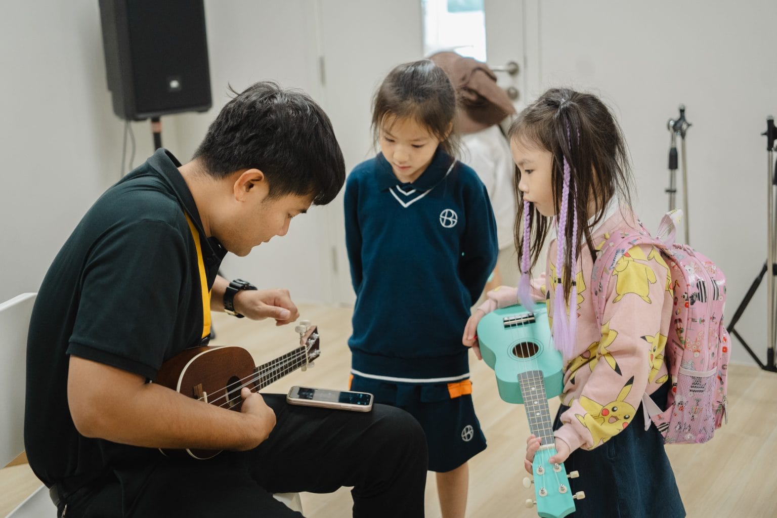 A music teacher showing pupils the ukulele