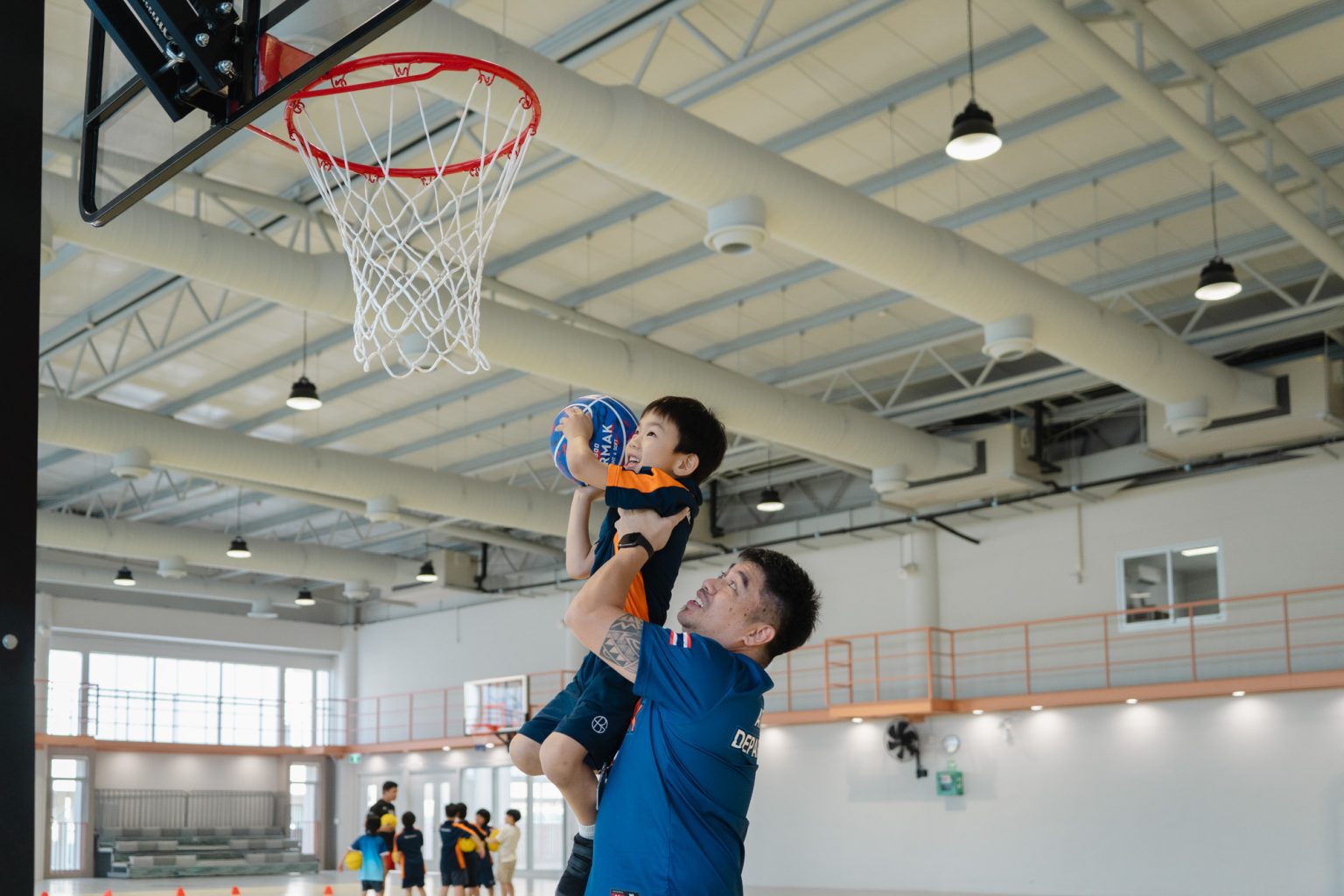 A pupil lifted up to the basketball hoop