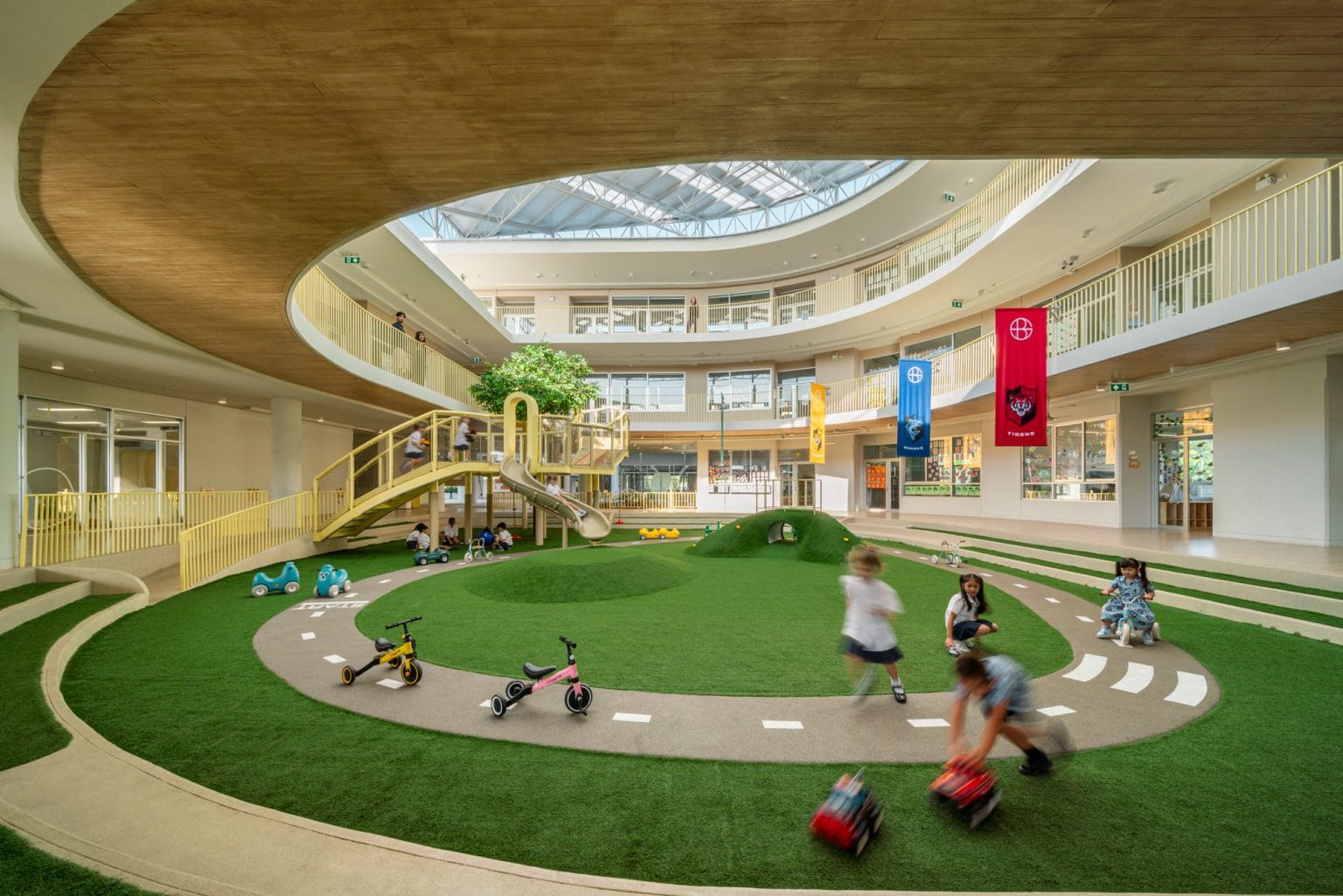 Children riding around the track on the indoor green