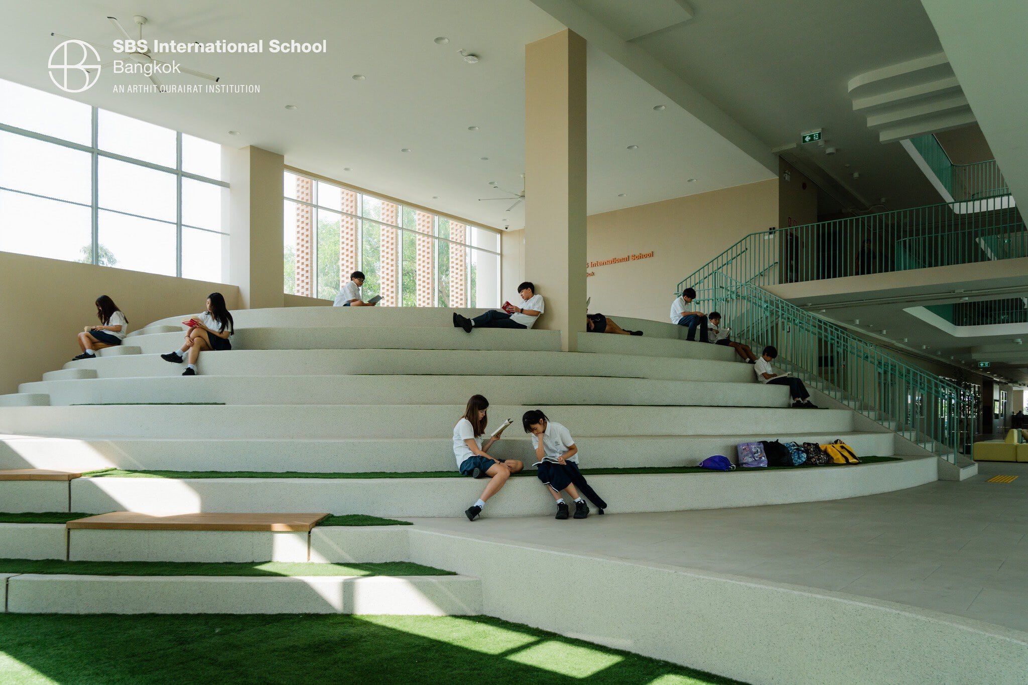 Students reading and relaxing in SBS Bangkok library during Book Week event.