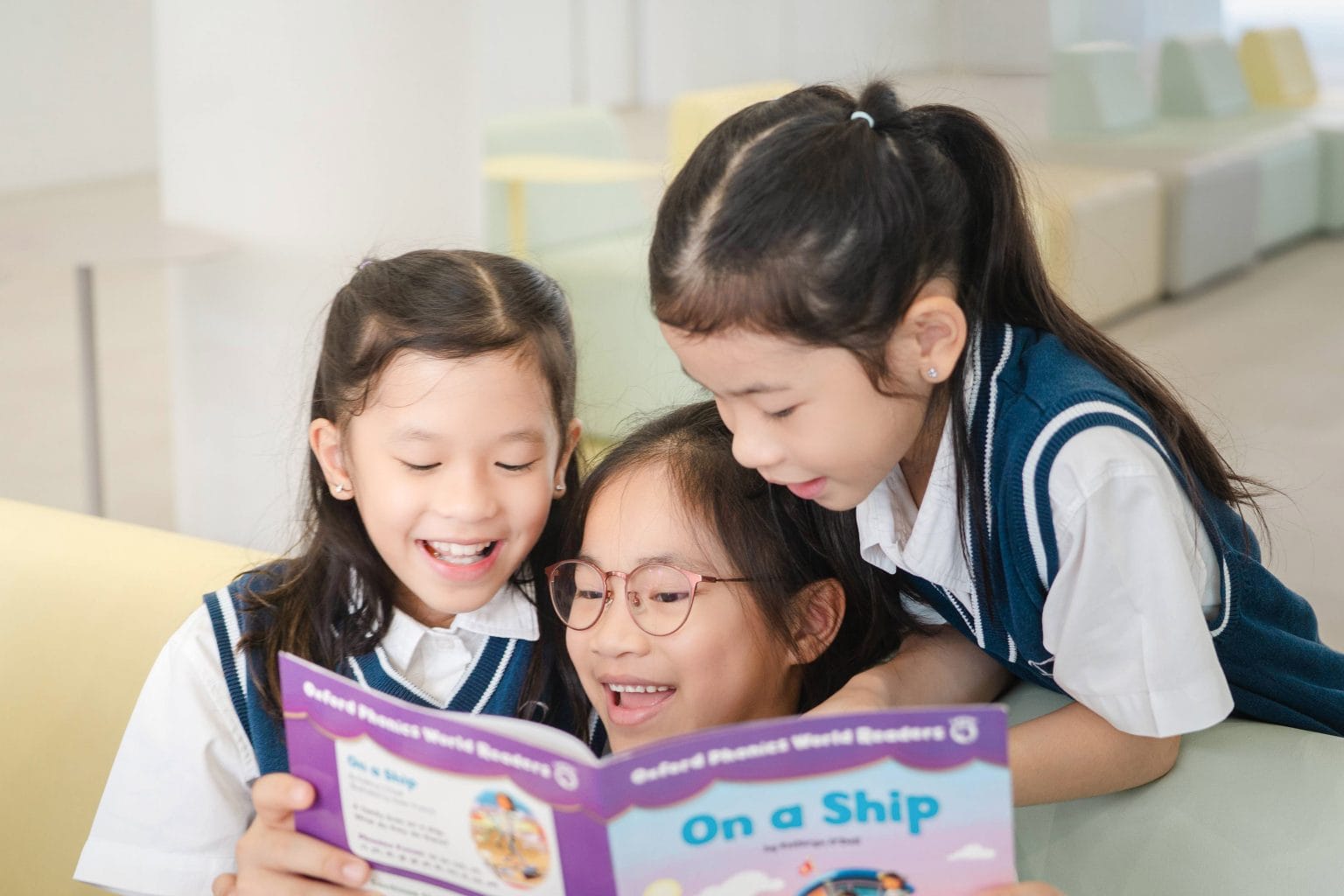 Three Year 1 girls reading a book together