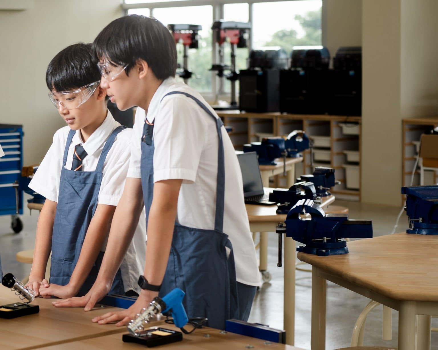 Two students at the soldering bench in the Design Innovation workshop