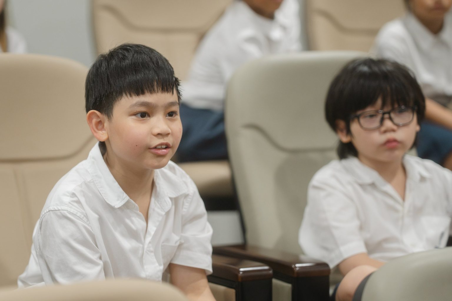 Two Year 5 pupils listening in an assembly