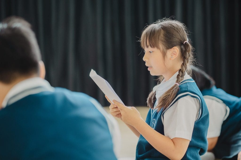 A Primary pupil reading aloud in class at SBS Bangkok